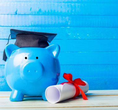 a blue piggy bank with a graduation cap on top of it.
